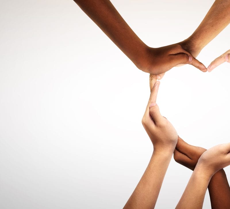 Multiple pairs of hands joining together to create a heart shape